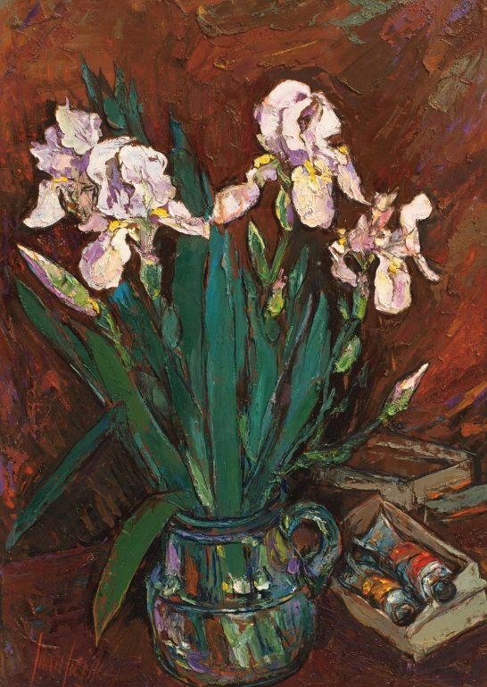 Lirios blancos Ramo de lirios en jarrón colorido sobre fondo rojo oscuro.