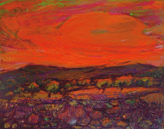 Nube roja Atardecer vibrante con cielos anaranjados y tonalidades de rojo sobre un paisaje montañoso.