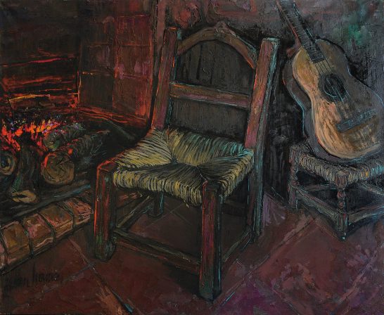 Mi hogar Silla de madera junto a una chimenea y una guitarra apoyada en una mesa.